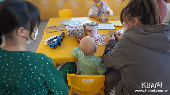 徐晓红和家人陪即将康复的儿子做游戏。 长城网·冀云客户端记者 王日成 摄 图片